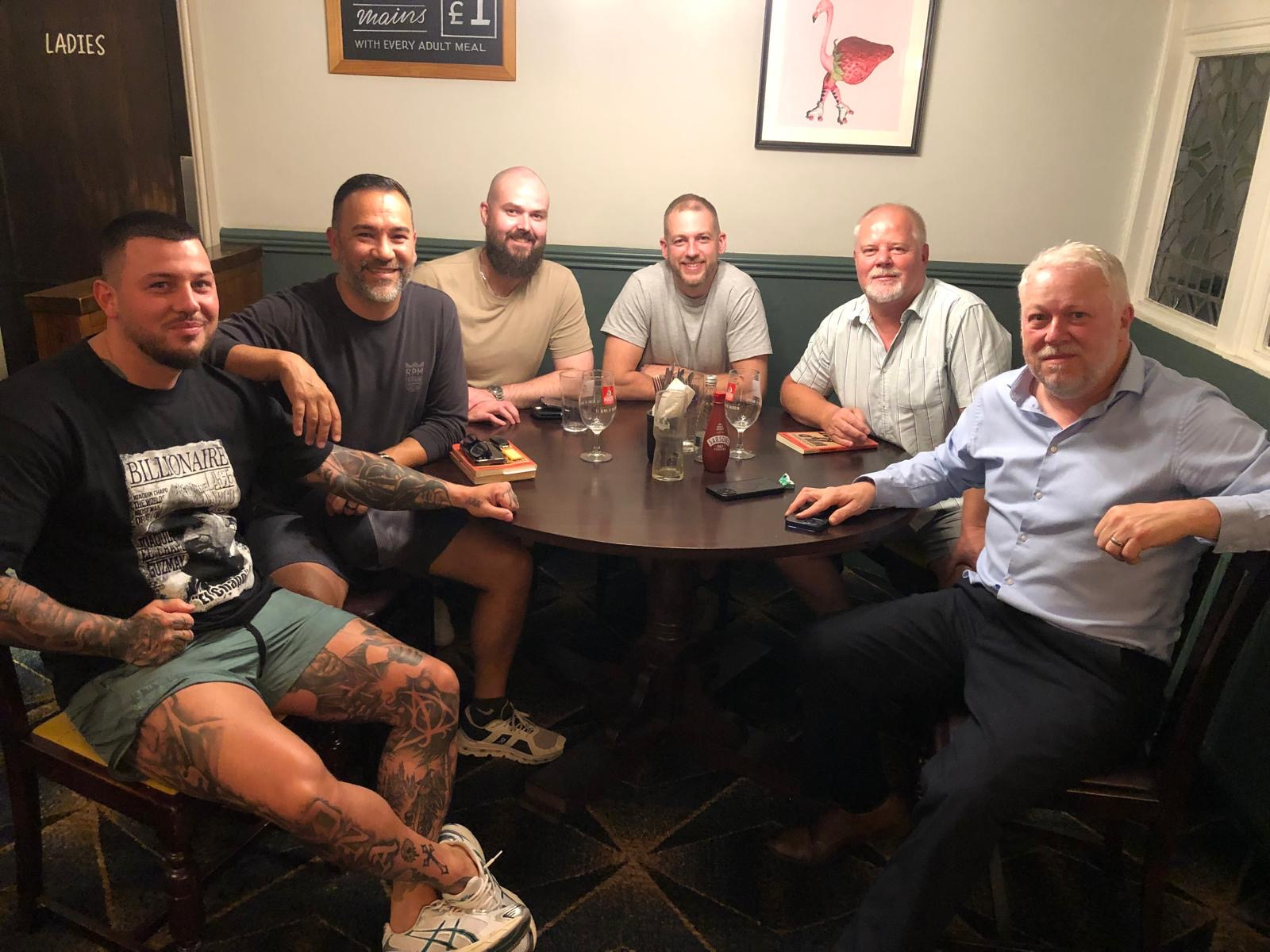 Men talking in a circle of chairs at Massey's Social Club